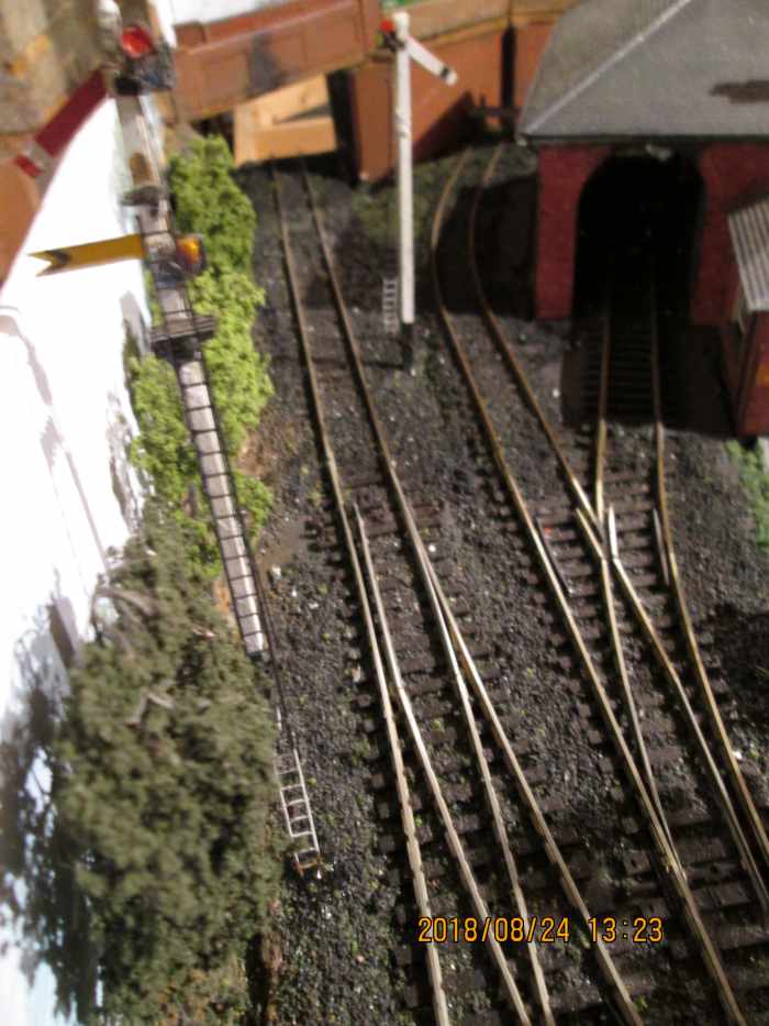 Visible over the occupation bridge parapet from the platform are the starter and fixed distant arms. As the branch is single track as far as the next station, caution is called for - spot the deliberate mistake? Both signals are 'off'!.