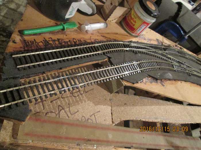 The grey underlay foam has been roughly cut to shape for the track formation, track in the coal depot suspended over the opening between buffer stop heading and main area