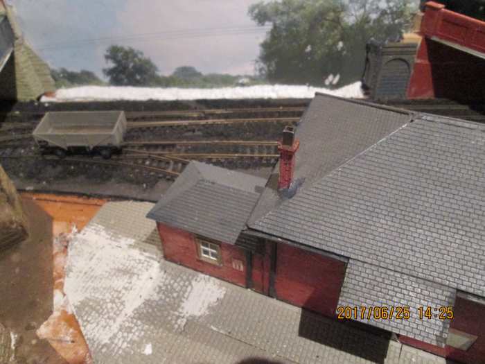 Behind the goods shed a stretch of backcene has been applied to the board. In front of that the gap between layout and backcene board, filled with styrofoam as a prelude to a low 'Terra Forma' embankment. Fencing will top this to give a 3D effect