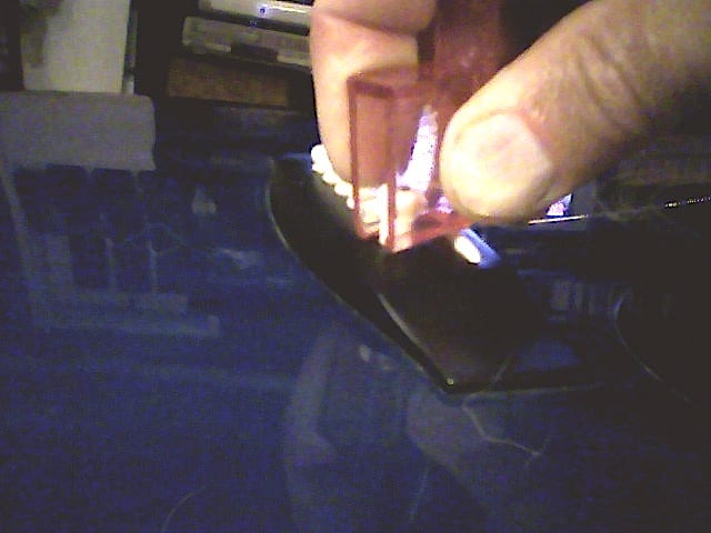 Removing bridge pegs. Much easier working from the direction of the strings! (That is, with the peg remover resting on the bridge saddle.)