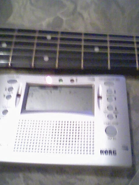 A chromatic tuner is a great help in tuning the guitar. Here, the leftmost LED is illuminated, showing that the string is flat.