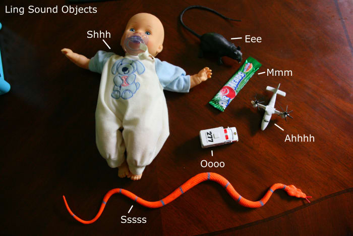 Sample objects to represent the Ling Six Sounds. Some sounds are fairly standard (the airplane for "ahh," and some may vary depending on the child - we use candy for "mmm").