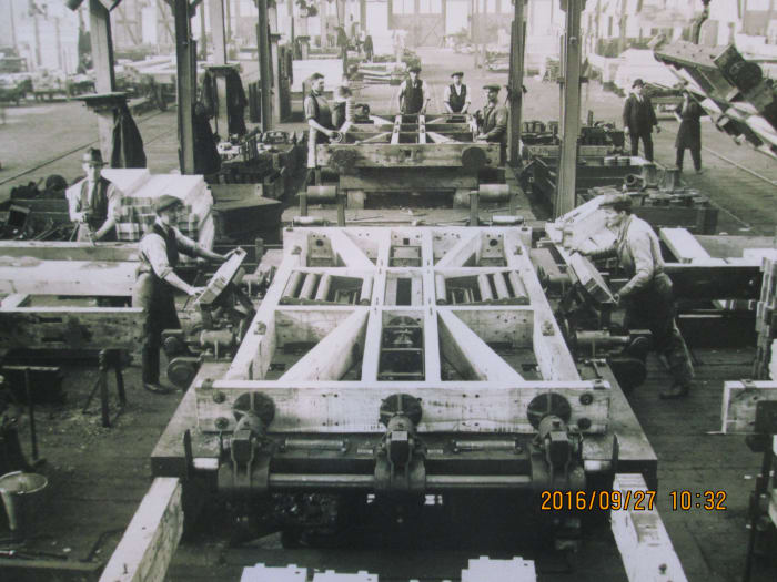 In the wagon workshops, early days - a frame has been assembled, now it has to be tightened. Work goes on apace elsewhere on the suspension, wheels, braking system, couplings, steel cross braces, planking and hinging for doors etc...