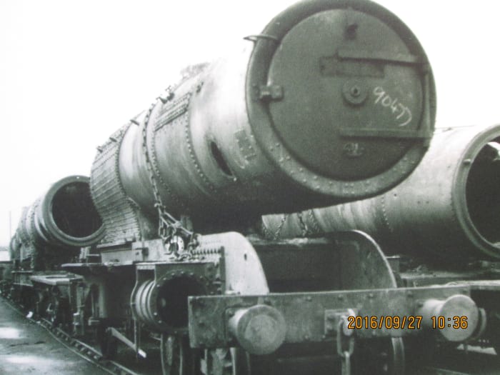 A completed boiler rests on a redundant NER Atlantic (4-4-2) locomotive frame, its cylinder housings and buffers still attached, screw coupling replaced by 3-link