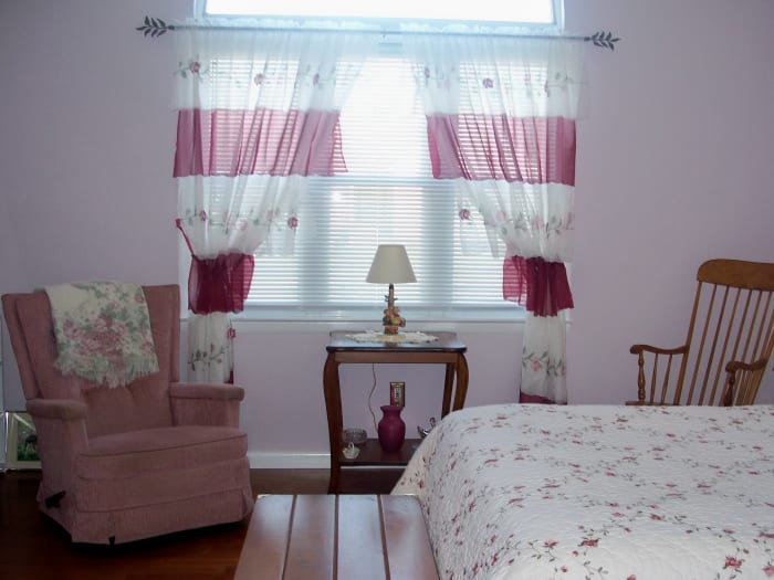 The room is large, so it easily holds a queen sized bed, a table and two chairs for lounging.