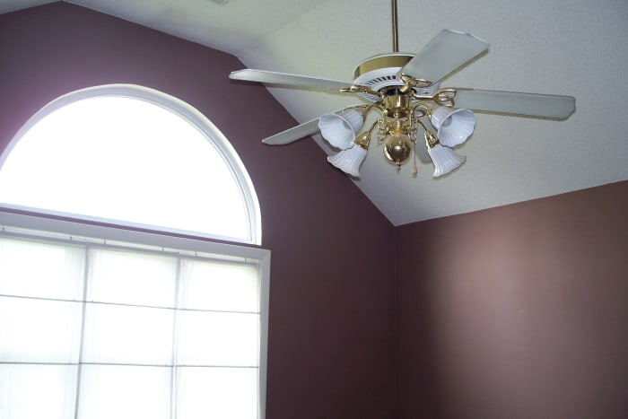 Before: Cathedral ceiling and large arched window are two good points in the master bedroom.