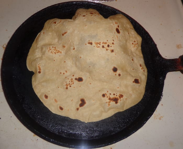When u press the chapati with a cloth; after flipping it once, you can see the chapati bulging. Now shift the chapati to a separate plate. Your soft home made chapati is ready to serve.