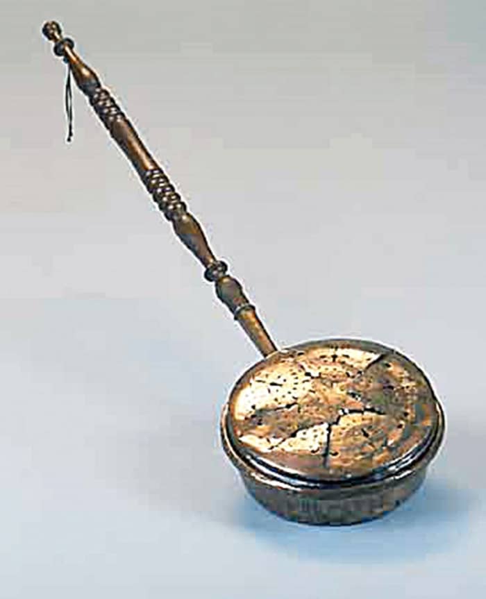 An old-fashioned bed-warmer which people used in the late 19th and early 20th century in the days before hot water bottles.