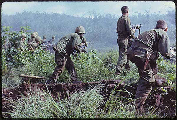 Dak To in South Vietnam. An infantry patrol moves up to assault a Viet Cong position after an attempted overrun of the artillery position by the Viet Cong during Operation Hawthorne.