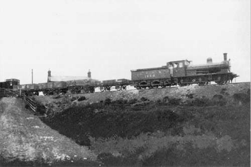 At Blowath Crossing ('Blue Ford', the water reflected the clear sky, named during a moment of quiet reflection in summer no doubt) Class J24 climbs wih a short rake of mixed open wagons. Vans would not pass under the cable drum.