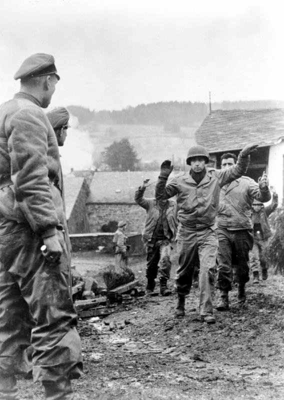 American troops surrendering to Waffen SS troops in the Battle for the Ardennes. Note the Waffen SS soldier with his had on his dagger.