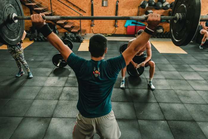 Standing Overhead Prress. Not shown: Version in which the barbell is pre-racked at shoulder height.