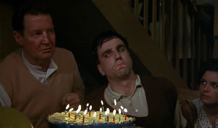 He is both the cake and the candles. What is that other guy looking at when he should be looking at the candle blower?