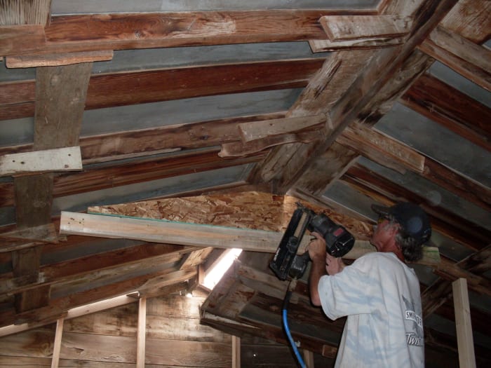 Use a nail gun to fasten brace to the rafters, but not to the 2x6 brace. The 2x6 is there only to hold things together until the triangle brace is in. The triangle sits on it. Shoot nails in at an angle through all the layers, deep into the rafters.