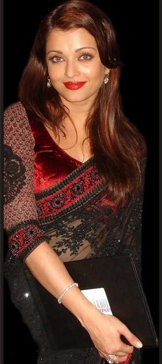 Ashwariya in a red-maroon velvet blouse with black net embroidered sleeves, worn with a black net saree.