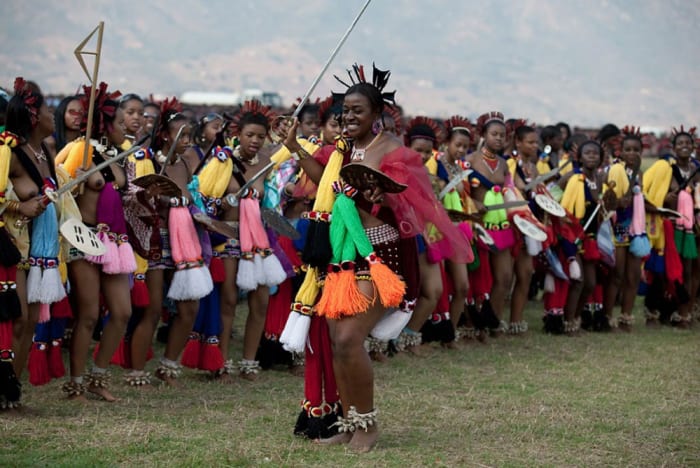 Members of the royal Swazi family dance with young girls dance at a traditional Reed dance ceremony at the stadium at the Royal Palace in Ludzidzini, Swaziland