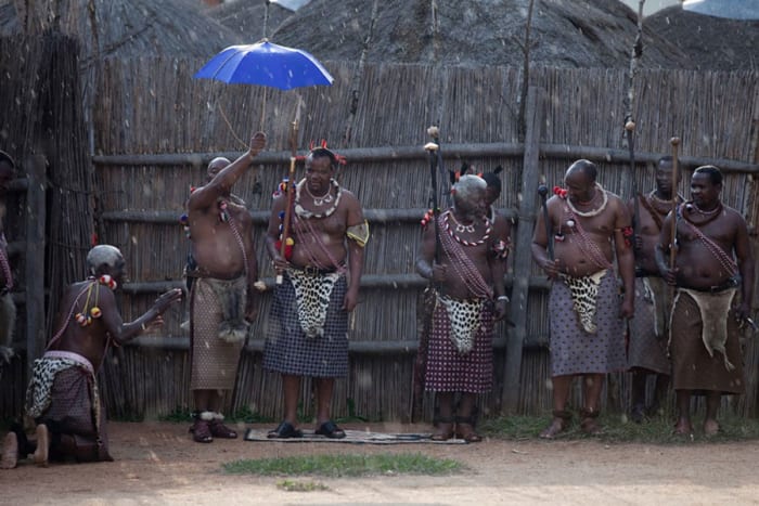 King Mswati III and members of the royal family watch a traditional Reed dance ceremony at the stadium at the Royal Palace