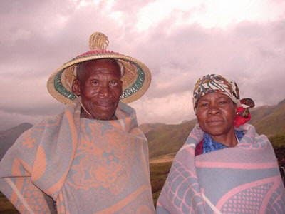 Basotho People with the Man wearing his 'grass'-made hat called Modianeo" and he and his wife waring a "Kobo"(Blanket.