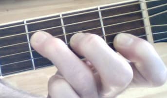 This is another way to get the F Major sound. Lay your first finger across the high E (first string), but do not push down. The string is being muted, you should hear a non-pitched sound, more of a scraping sound on the note