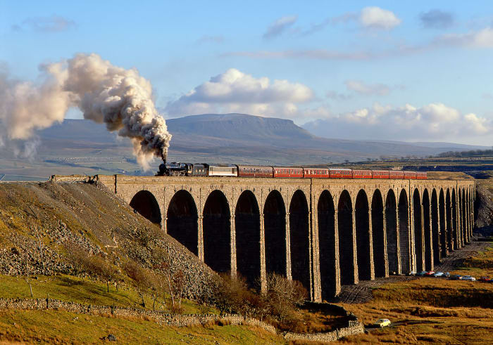 Ribblehead Viaduct looking south-east on a bright day with a preserved Black Five in LMS livery hauling a Cumbrian mountain steam special