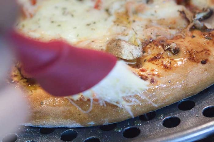 Golden Tip: As soon as the Pizza comes out of the oven, brush the edges of the fluffy pizza base with olive oil. The oil will soak into the base and make it even more delicious