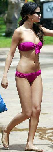 Selena Gomez walks with Justin Beiber (not in picture) flaunting her hot bikini body in Hawaii. This Selena Gomez bikini scores points for the pretty knot on tn the bikini top.
