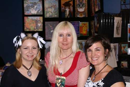 Here I am at Dragon * Con 2008 With artist friends Carrie Hawks on the left, and Deanna Davoil on the right. I'm the tall blonde in the center. Lol! The cat art in the background is the work of talented fantasy cat artist Carrie Hawks.