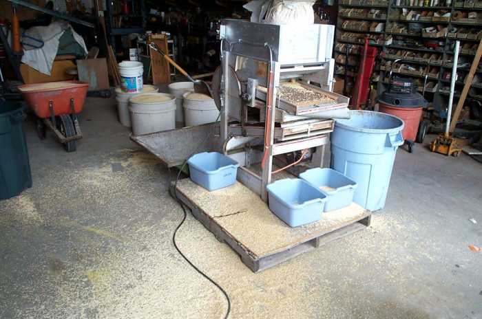 The fan mill is a machine designed to shake grain, a little at a time, from a hopper onto a series of screens. Debris are discarded as the grain moves from one screen to the next..