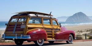 The car now best known as the woody, named in honor of its distinctive wood paneling. Shown here carrying a surf board on its roof - almost as a trophy in celebration of the surfing industry.