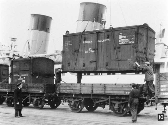 Unloading containers, 1950s - early days yet, no hi-viz here either - not by the book, loading container into 3-plank wagon where there are no chain pockets for securing!