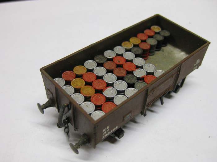 13 ton LNER Steel open, painted dark (weathered) bauxite, built as 'fitted' with vacuum pipes but with 3-link Smiths' couplings. Part loaded with strips of painted 'steel' drums.