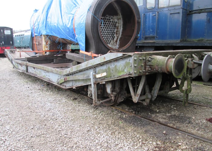 Briitish Railways machine wagon with instanter coupling and vacuum pipe; loaded with small tarpaulined locomotive boiler load seen at Embsay Station near Skipton on the Embsay & Bolton Abbey Railway in North Yorkshire (formerly West Riding)
