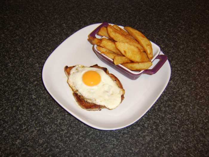 A simply fried pork chop, topped by a fried egg and accompanied by freshly homemade chips makes for an excellent dinner