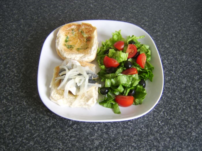 A pickled herring fillet on a herb buttered burger bun with salad makes a fairly unorthodox but delicious meal!