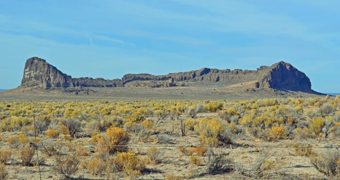 Driving towards Fort Rock State Park seeing the massive fort-like rock structure rising out of seemingly nowhere.