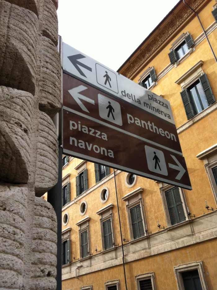 Street sign outside the church of San Luigi for Piazza Navona and the Pantheon which are within 100 meters