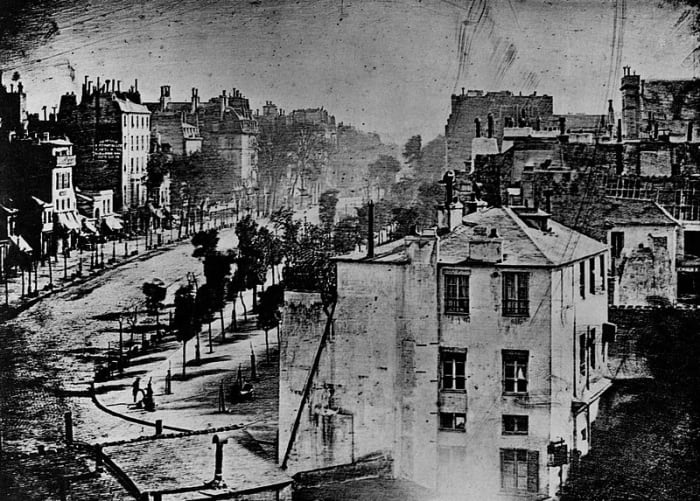 The first photograph to feature a person - a man having his shoes shined on the corner of the street This work is in the public domain in the United States, and those countries with a copyright term of life of the author plus 100 years or less..