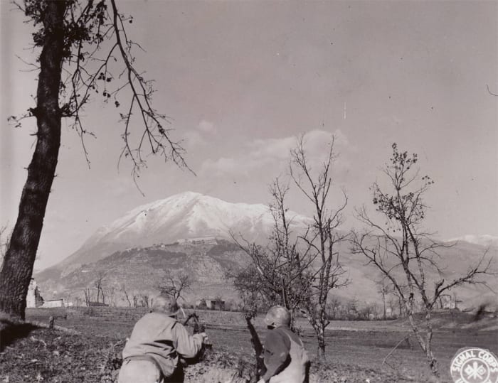Two GIs in the Rapido Valley look out upon The Abbey at Monte Cassino. Brutal terrain caused excessive delays and created great defensive positions for the Germans.