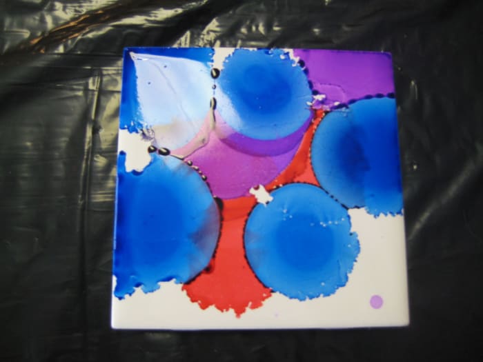 Continue adding colors, overlap them.. Here you can blow on the ink to get it to move in a certain direction if you want, or let it move where the alcohol moves it.