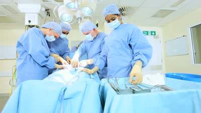 Multi ethnic medical team performing operation in hospital operating theater