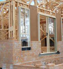On this low-set brick-veneer the bricklayers have started constructing the brick veneer outside. it is a good photo to show the construction here, but what seems to be missing is the insulating building paper that is nailed to the timber frame.