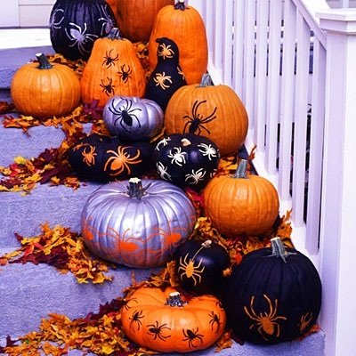This idea using a bunch of painted and drawn on with spider stencils is just a couple of many DIY easy pumpkin decorating ideas.