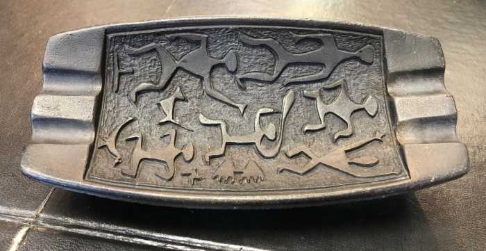 This is a Coco Joe's mid-century ashtray made in Hawaii from lava. It has Hawaiian dancers and symbols on the front. Ashtray measurments 6 1/2” long 3” wide 1 1/4” tall.