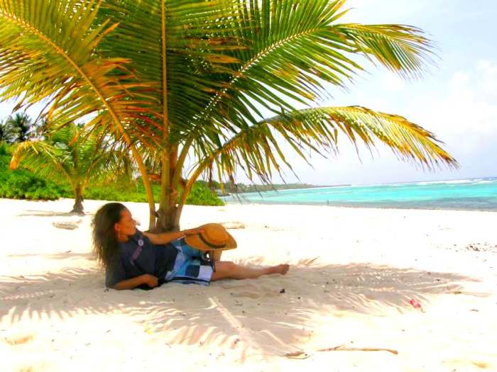 The author relaxing under a coconut palm at one of her favorite hangouts, Spotts cemetery beach