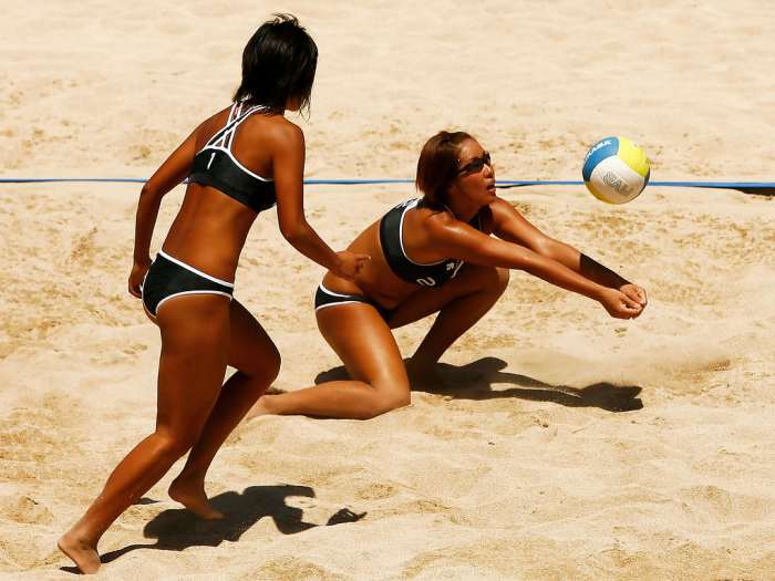 Ayumi Kusano (right) hits the ball as her partner Mutsumi Ozaki looks on.