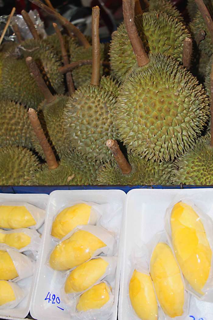 Durian - one of the most popular, yet pungently smelly, fruits! The whole fruit is shown above, and below it is sliced and cellophane wrapped ready for sale