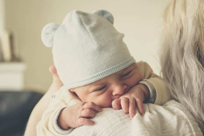 A tried and true tactic to prevent spitting up is to hold your baby upright after a feeding. That underdeveloped digestive system is much happier when gravity isn't working against it.