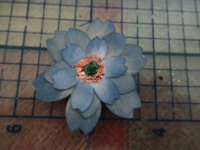 I created these flowers with a simple punch. They were colored with distress ink. Gilding flakes were added to the center.