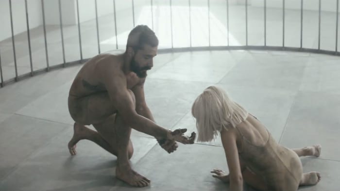 In one of the scenes in this music video, Shia holds out his hand to the beautiful Maddie as while portraying ths story inside of a cage.