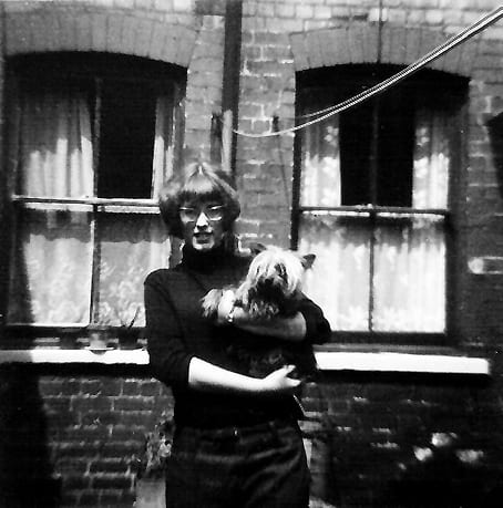 Me standing outside the back of the home I grew up in the window to the left is ours the one to the right belongs to next door.